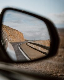 Rear view through the right wing mirror of a car on a winding road in morocco