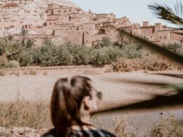 A woman is looking at the historic town of Ait Benhaddou in Morocco