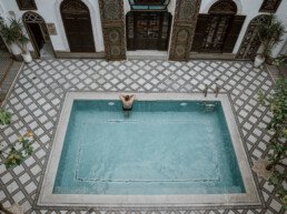 man relaxing in the pool of riad maison bleue in fes